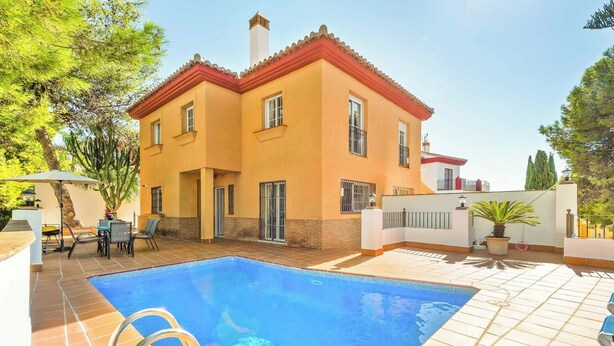 A two-story house with a swimming pool, outdoor furniture, and a tiled patio. - Villa Clarence (Nerja)