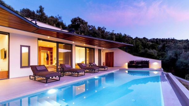 A modern house with a swimming pool, lounge chairs, and a wooden deck. - Villa Beyond the Horizon (Lefkada)
