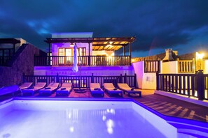 A swimming pool with lounge chairs and a building with a balcony. - Vista Rey (Yaiza)