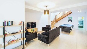 A modern living room with a pool table, a sofa, a TV, and a bookshelf. - Vista Rey (Yaiza)