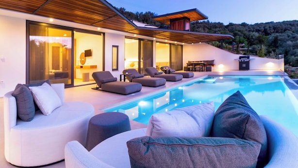 A modern house with a swimming pool, outdoor seating, and a view of the hills. - Villa Beyond the Dream (Lefkada)
