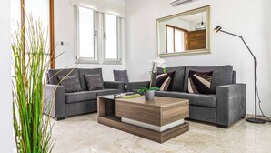 A modern living room with a grey sofa, a wooden coffee table, and a floor lamp. - Villa Alasia (Paralimni)