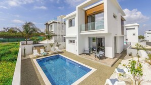 A modern two-story house with a swimming pool, outdoor seating, and a garden. - Villa Alasia (Paralimni)