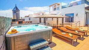 A rooftop pool area with a hot tub, lounge chairs, and a small tower structure. - Villa Xian (Yaiza)
