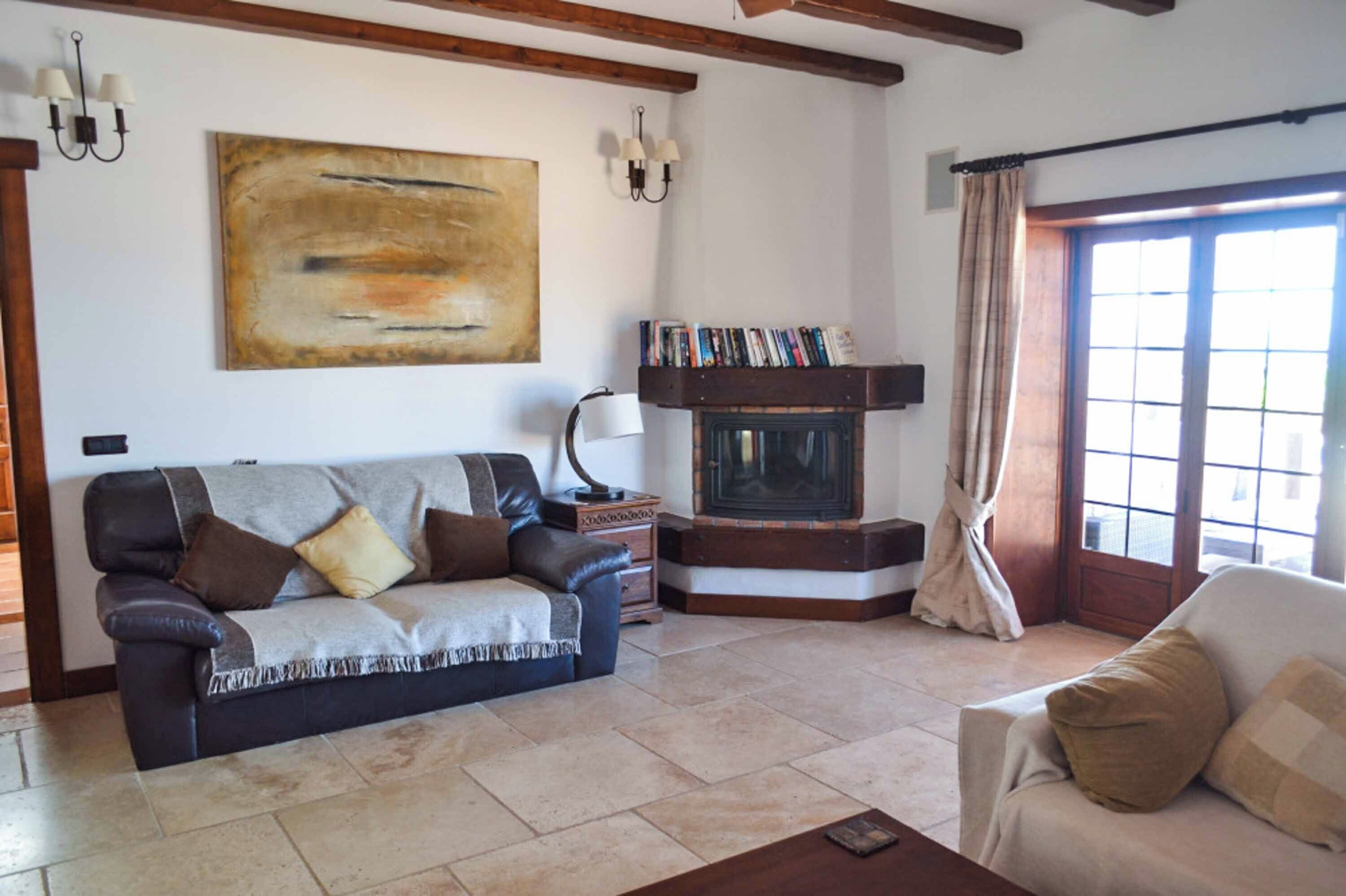 A living room with a fireplace, a sofa, a coffee table, and a bookshelf.