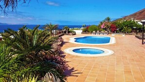 A pool area with two circular pools and a view of the ocean. - Villa Buena Vista Bocaina (Yaiza)