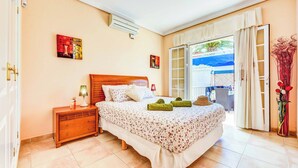 Un dormitorio con cama, mesita de noche y vistas al exterior.