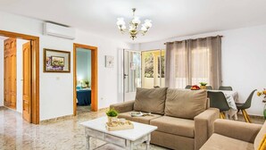 Una sala de estar con sofá, una mesa de centro y una zona de comedor con mesa y sillas.