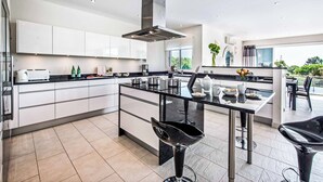A modern kitchen with white cabinets, a black countertop, and stainless steel appliances.