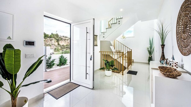 A modern interior with a glass door leading to a balcony, a staircase, and a reception desk. - Villa Aventura (Albufeira)
