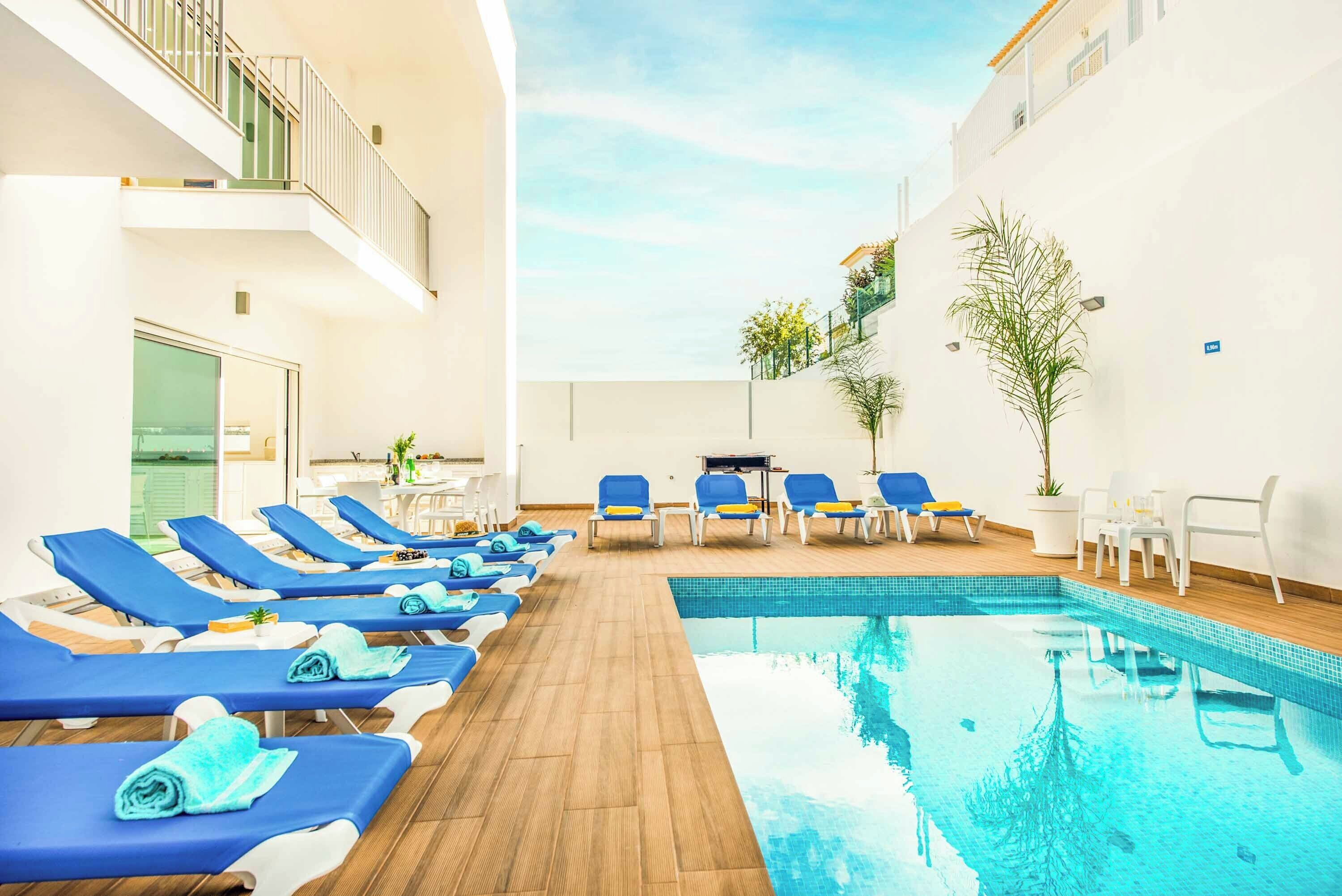 A poolside area with sun loungers and a small pool.
