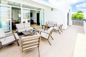 A modern outdoor patio with a sofa set, a dining table, and a bar area. - Villa Bella (Yaiza)