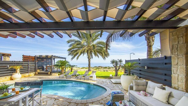 A pool area with a pergola, lounge chairs, and a sofa. - Villa El Greco (Paralimni)