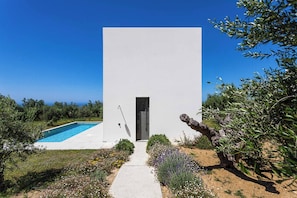 A modern building with a pool and a pathway leading to the entrance. - Villa Kalypso III (Pylos-Nestoras)