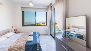 A modern hotel room with a large bed, a view of the sea, and a balcony. - Villa Alderbaran (Pegeia)
