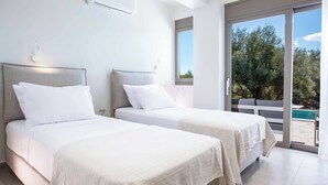 A hotel room with two beds, a large window, and a view of the outdoors. - Villa Averto Irene (Lefkada)