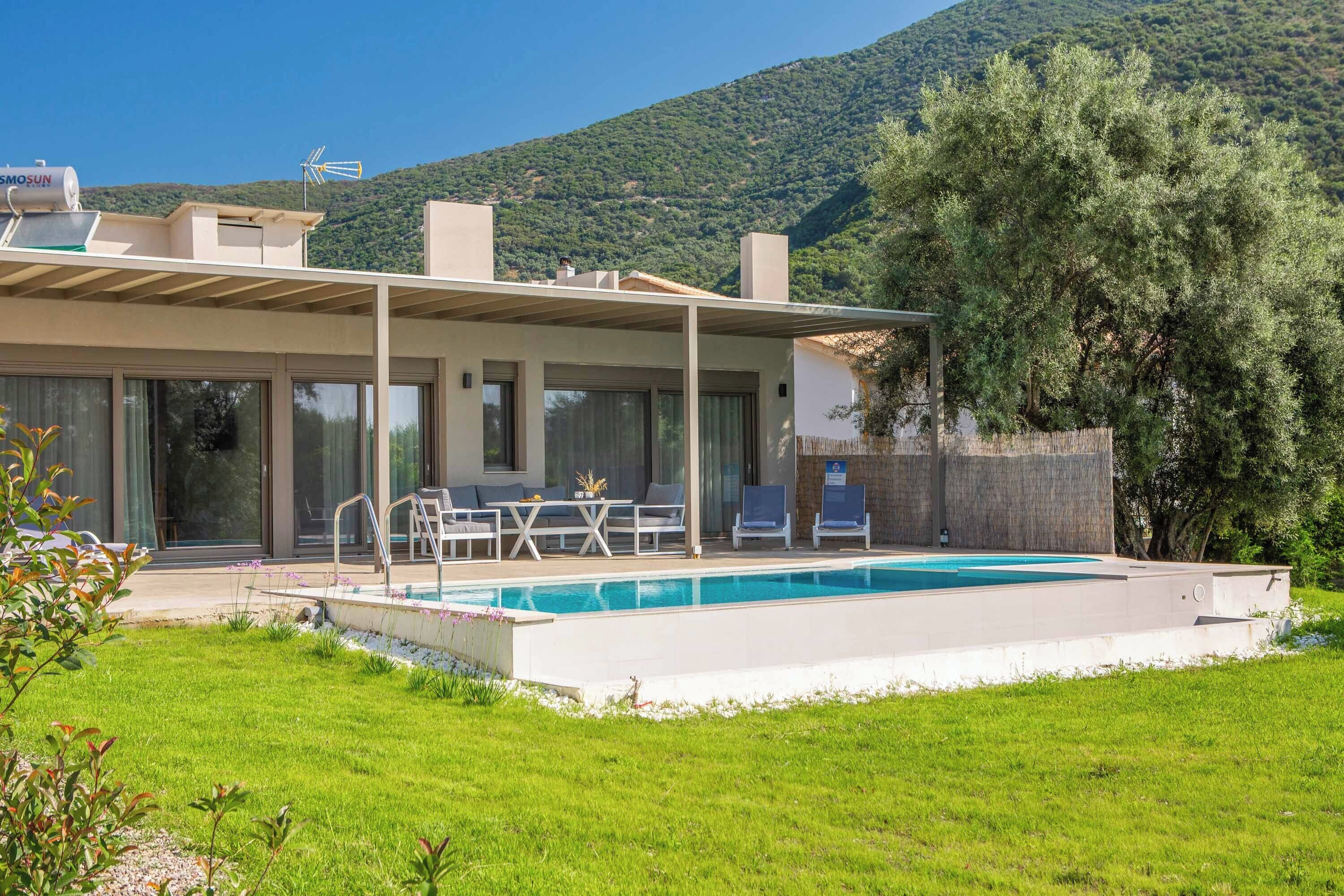 A modern house with a swimming pool, outdoor seating, and a view of a mountain.