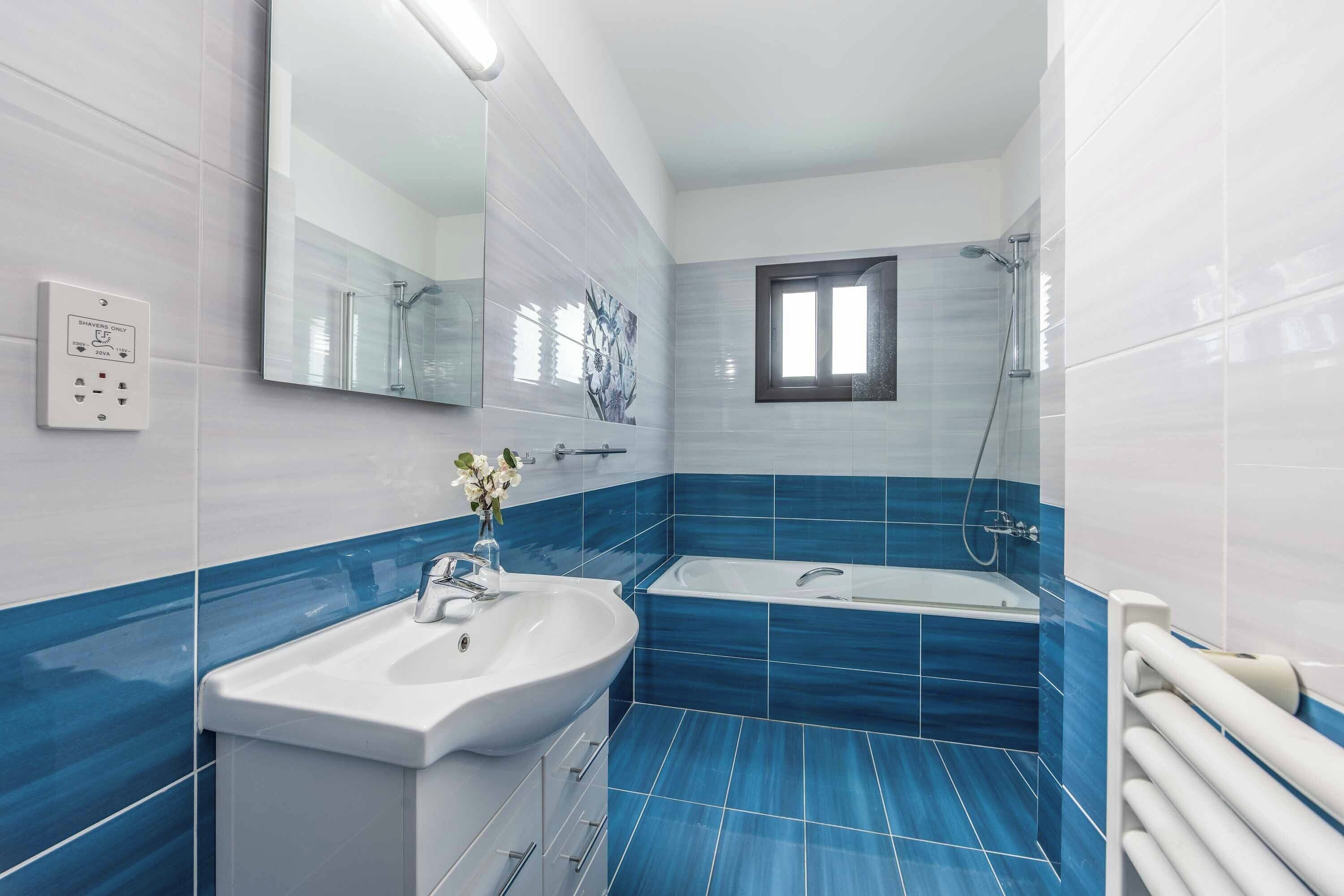 Une salle de bain avec un lavabo, un miroir et une douche.