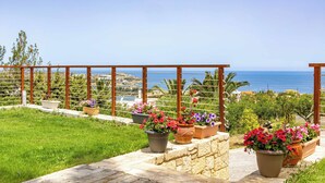 Un balcón con plantas en macetas y vista al mar.