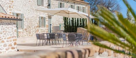 A stone building with outdoor seating and a covered patio.