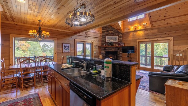 A wooden cabin interior with a kitchen, dining area, and living room. - Morris Cabin (Boone)