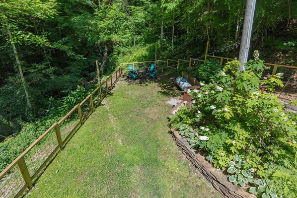 A fenced garden area with a wooden bench, a small table, and chairs. - Sugar Tree with fully fenced in yard! (Bryson City)