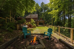 A wooden deck with two green Adirondack chairs facing a fire pit. - Sugar Tree with fully fenced in yard! (Bryson City)