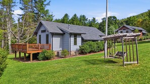 A two-story house with a covered porch and a small deck. - Banner Sky (Banner Elk)