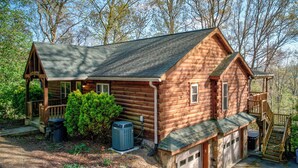 A log cabin with a porch, a garage, and a covered staircase. - Chestnut Lodge (Boone)