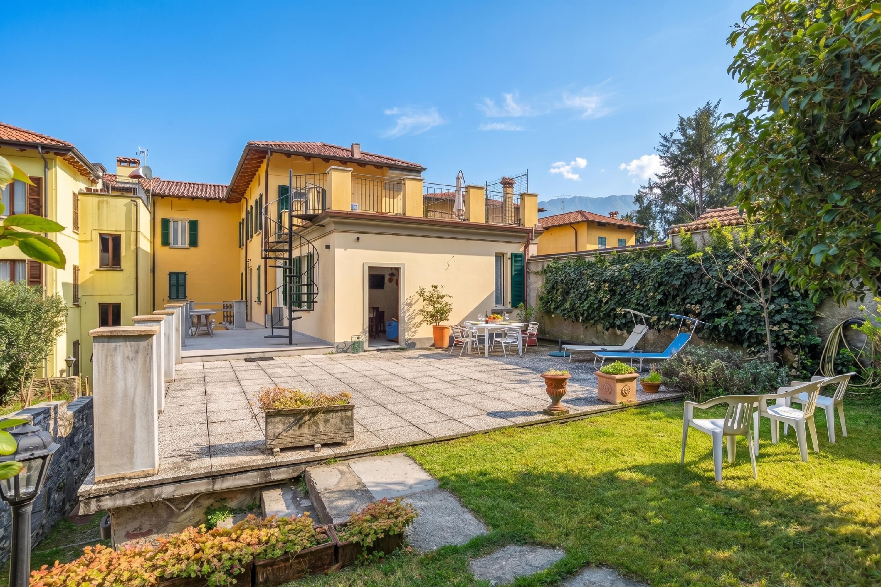 A residential property with a patio, outdoor seating, and a view of the surrounding area.