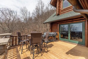 A wooden deck with wicker chairs and a grill area. - Good Day Sunshine (Lenoir)