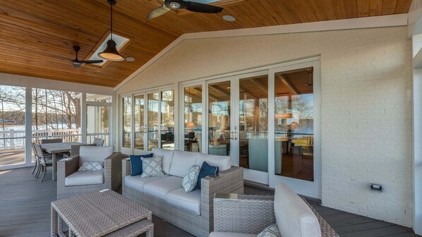A covered outdoor seating area with a sofa, chairs, and a table.