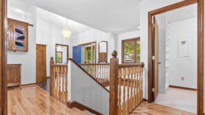 A spacious interior with a wooden staircase, white walls, and a view of the outdoors. - Lake Relaxin` | Fabulous Flat Lot | Great Water View! (Henrico)