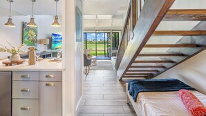 A modern interior with a kitchen, dining area, and a bedroom with a view.