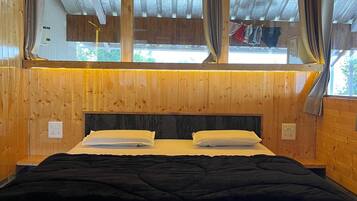Relax in this serene bedroom with a large bed and a window offering a view of the outdoors.