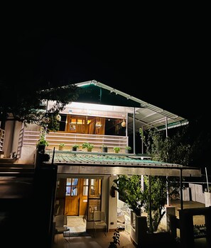 Vista frontal de la propiedad por la tarde o noche