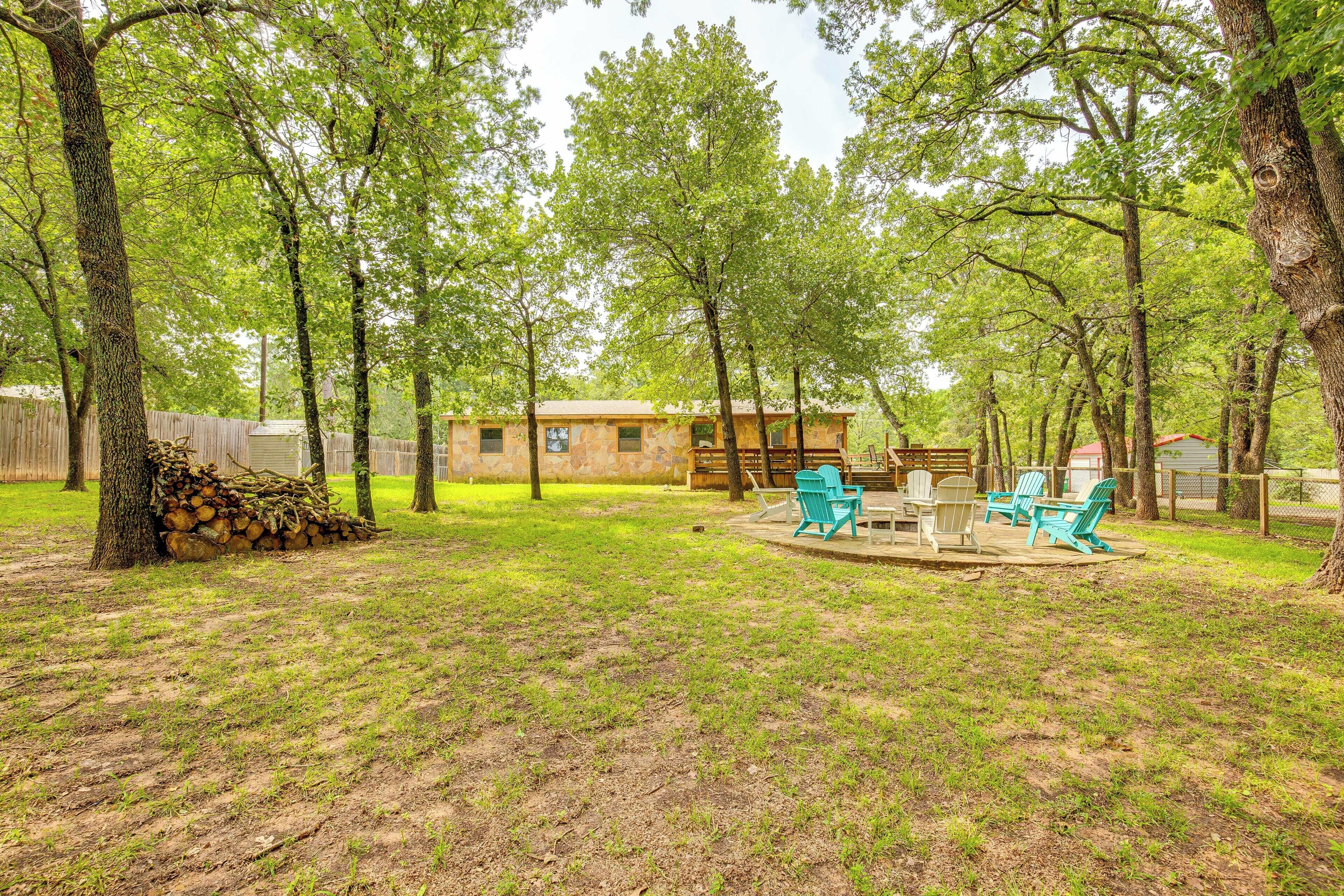 A backyard with a wooden cabin, a fire pit, and outdoor seating.