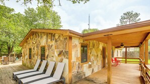 A stone building with a wooden deck, outdoor seating, and lounge chairs. - Deck & Fire Pit: Unique Pottsboro Haven (Pottsboro)