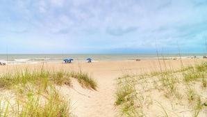 Une plage avec des dunes de sable et un ciel dégagé.