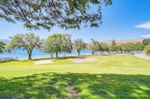 Un campo de golf con vistas despejadas al agua y colinas al fondo.