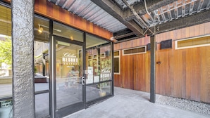 Un bâtiment à l’extérieur en bois et dont l’entrée est en verre.