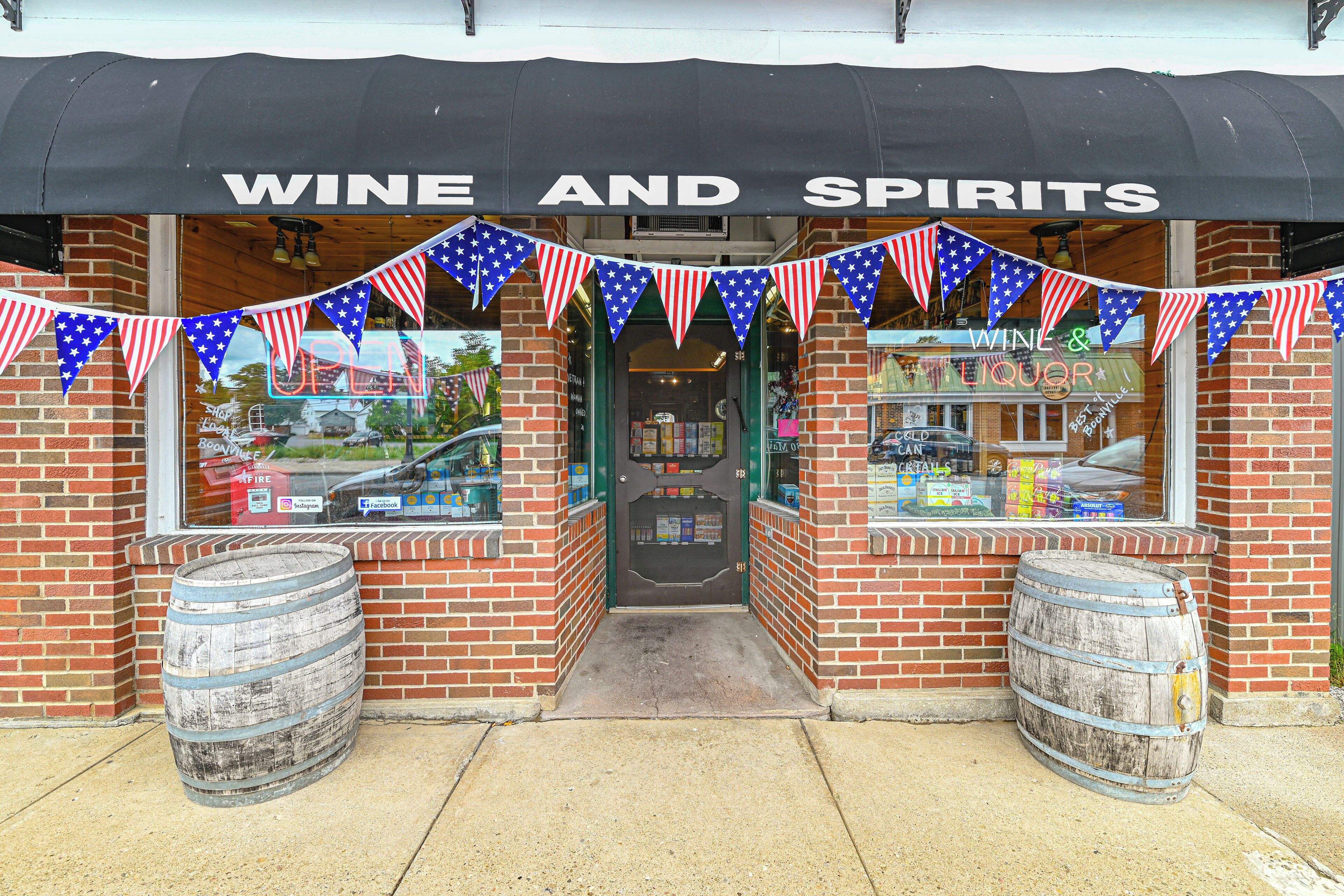 A storefront with a sign reading "WINE AND SPIRITS" and American flag decorations.