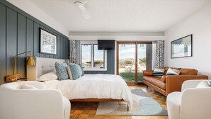 Un dormitorio moderno con una cama grande, un sofá y un televisor.