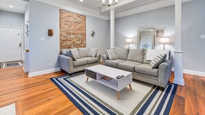 Ein modernes Wohnzimmer mit zwei grauen Sofas, einem weißen Couchtisch und einem Streifen Teppich.