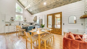 Une cuisine spacieuse avec un plancher en bois, des meubles blancs et une grande table à manger.