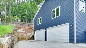 A two-story house with a blue exterior and white garage doors. - Kayaks, Boat Slip, Game Room, Calm Cove, Great Loc (Osage Beach)