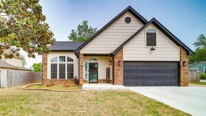 A single-story house with a garage, a front porch, and a well-maintained lawn. - 'peace & Tranquility': Home 2 Mi to Dtwn Tulsa! (Tulsa)