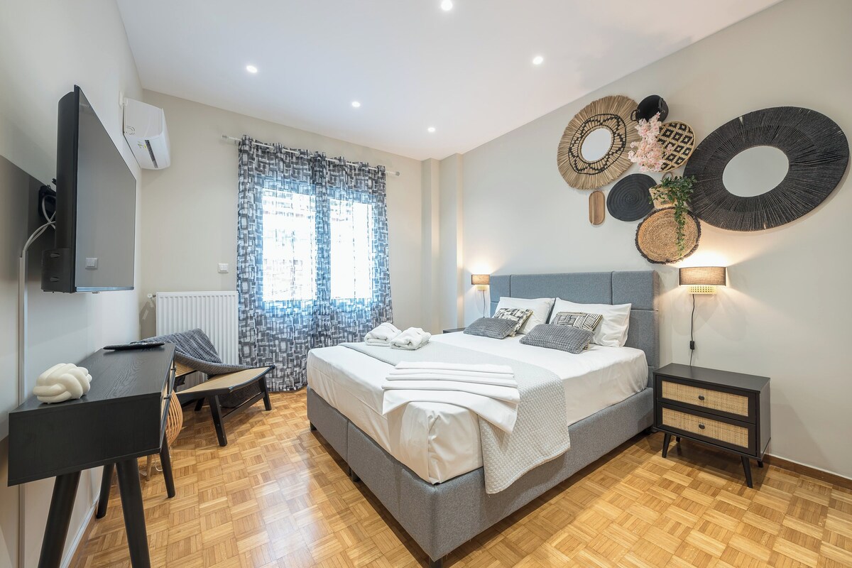A modern bedroom with a large bed, a desk, and a chair.