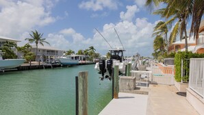 A marina with boats docked, a dock, and a building with a balcony. - Large home with a private pool! (Key Colony Beach)