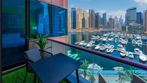 A balcony with a view of a marina and city skyline. - Modern 2BR with full Sea View | Pool & Gym (Dubai Marina)